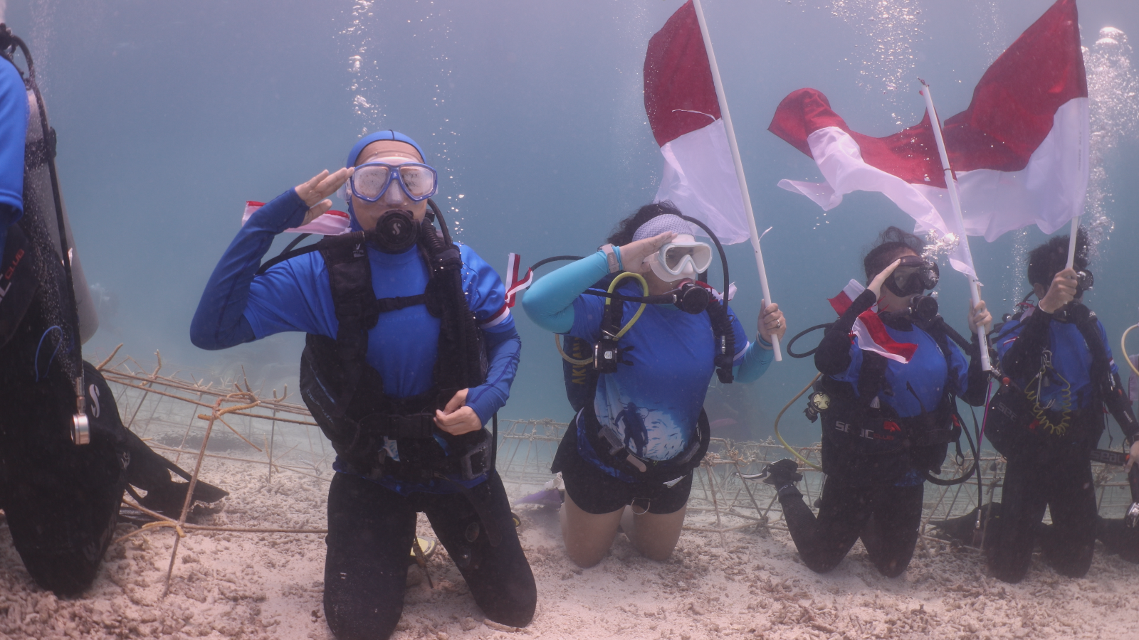Penyelam Berau Divers memberi hormat saat mengibarkan Merah Putih di bawah laut.